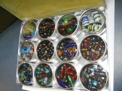 1.5 POUNDS MOSTLY GLASS BEADS IN A ALUMINUM CASE WITH 12 STORAGE CONTAINERS